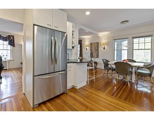 140 Cedar Street Lexington, MA 02421 - Photo 5 of 29 a kitchen with stainless steel appliances granite countertop a refrigerator a stove a dining table and chairs with wooden floor