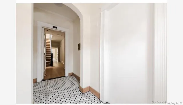 a view of a hallway with wooden floor and a bathroom