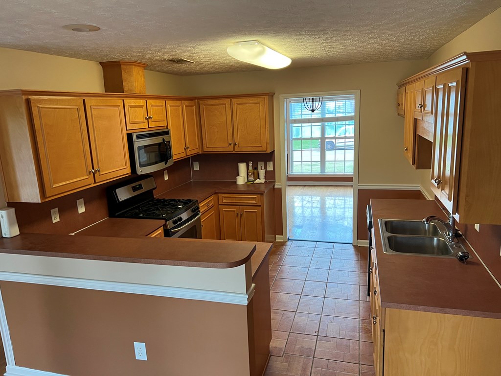 3003 Waterhill Drive Midland, GA 31820 - Photo 2 of 13 a kitchen with stainless steel appliances a sink a stove a microwave a sink a refrigerator and dishwasher