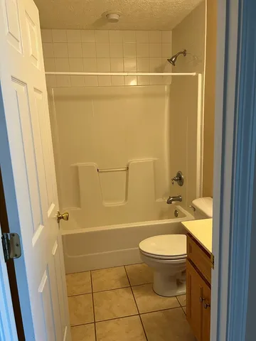 a bathroom with a granite countertop toilet a sink and shower