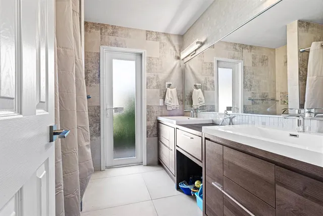 a spacious bathroom with a double vanity sink a mirror and a shower