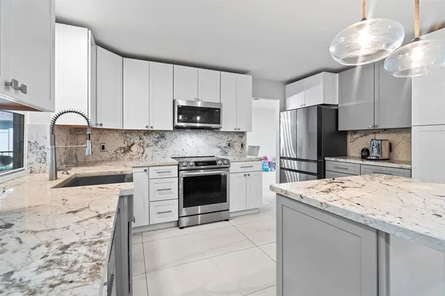 a kitchen with stainless steel appliances a stove refrigerator sink and microwave