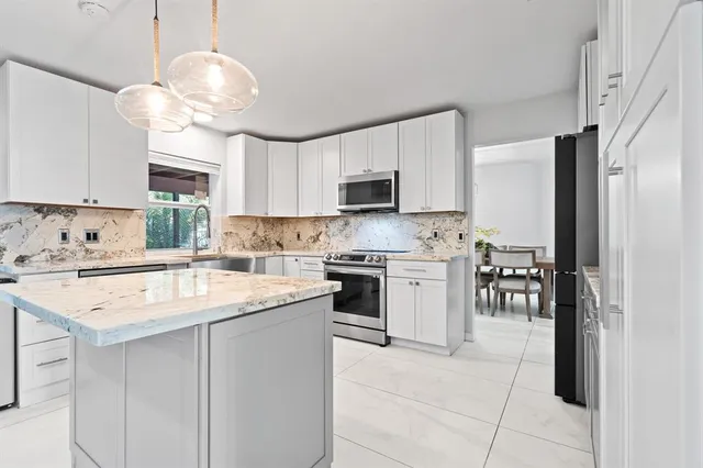 a kitchen with a stove a sink a refrigerator and a microwave