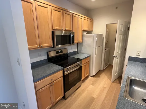 a kitchen with stainless steel appliances a refrigerator sink and microwave