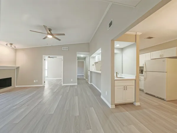 a view of a kitchen with wooden floor and a refrigerator
