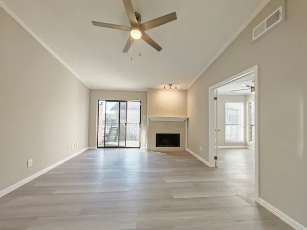 a view of an empty room with a fireplace and a window