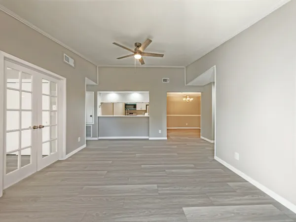 a view of an empty room with a window and wooden floor