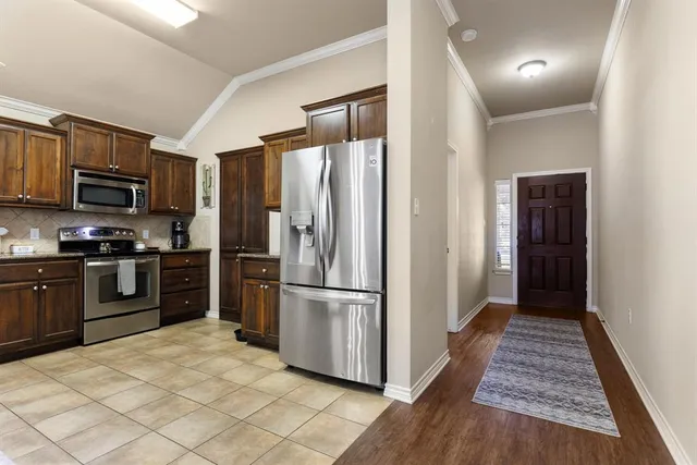 a kitchen with stainless steel appliances granite countertop a refrigerator and a sink