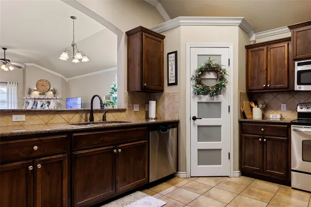a kitchen with granite countertop a refrigerator and a sink