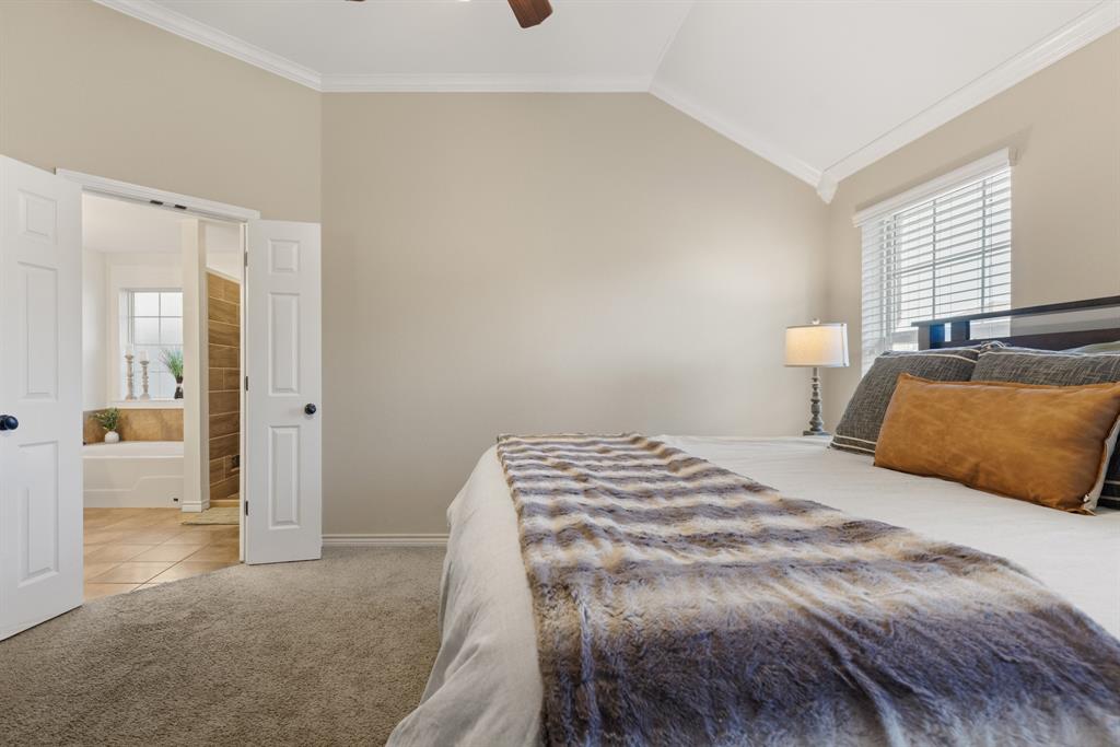 2565 Paddock Lane Robinson, TX 76706 - Photo 20 of 32 Bedroom featuring crown molding, vaulted ceiling, multiple windows, light carpet, and ceiling fan