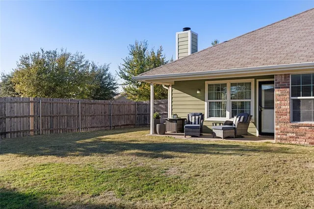 a view of a house with a yard and sitting area