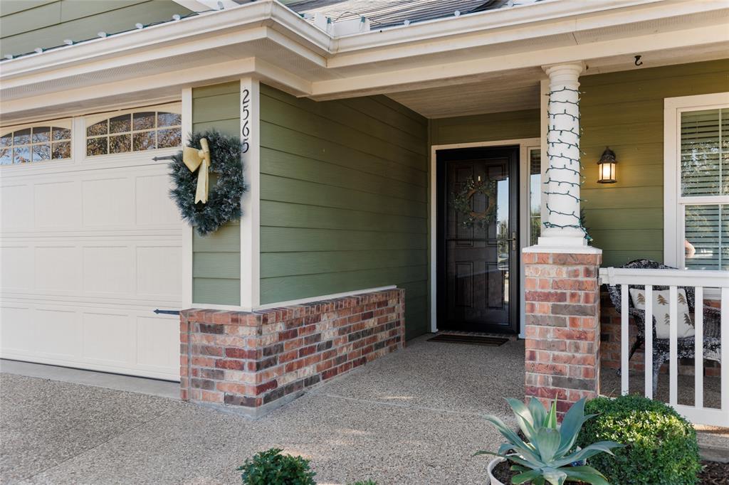 2565 Paddock Lane Robinson, TX 76706 - Photo 4 of 32 Doorway to property featuring a garage, a porch, and brick siding
