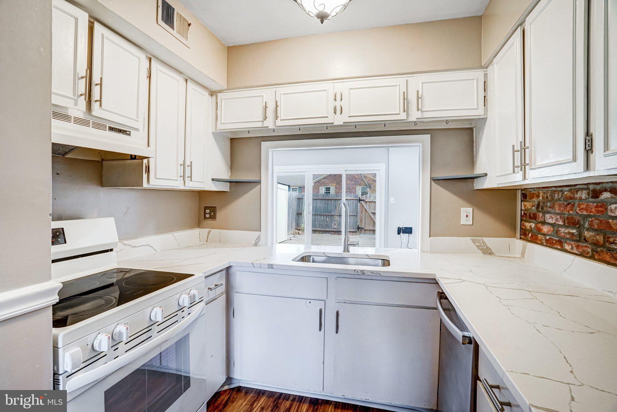 8396 Forrester Boulevard, Unit 555 Springfield, VA 22152 - Photo 8 of 24 a kitchen with stainless steel appliances granite countertop a sink and cabinets with wooden floor