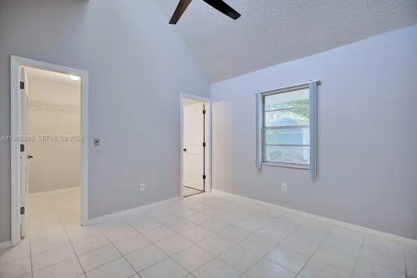 an empty room with windows and fan