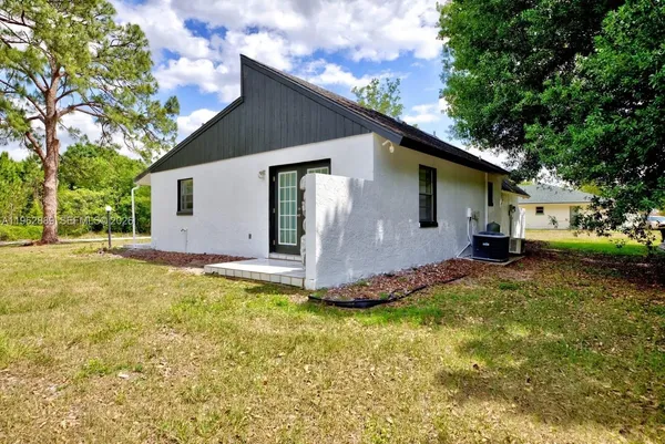 a view of a house with backyard and trees