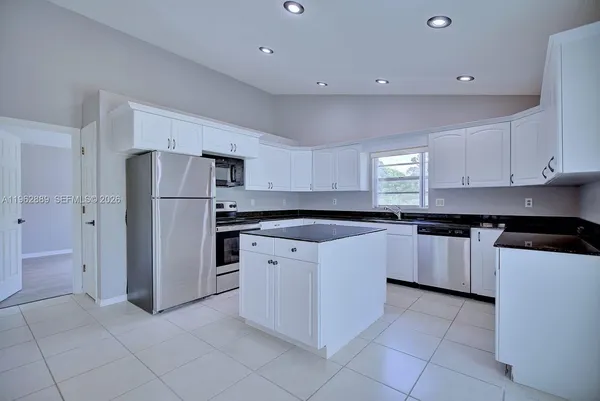 a kitchen with stainless steel appliances granite countertop a refrigerator and a stove