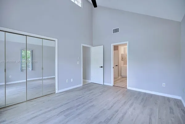 an empty room with wooden floor and mirror