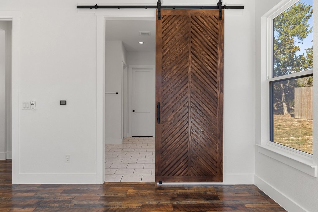 47 Peace Pipe Wimberley, TX 78676 - Photo 12 of 28 Corridor featuring a barn door, wood finished floors, and recessed lighting