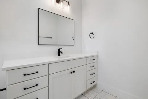 a bathroom with a sink vanity and mirror