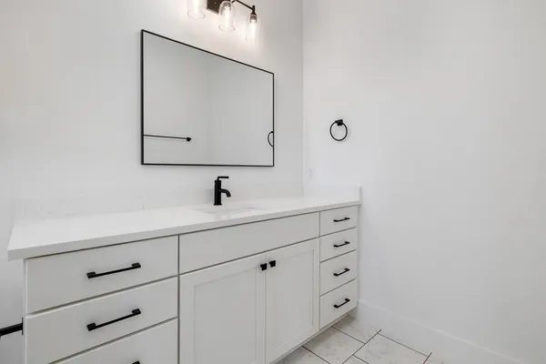 a bathroom with a sink vanity and mirror