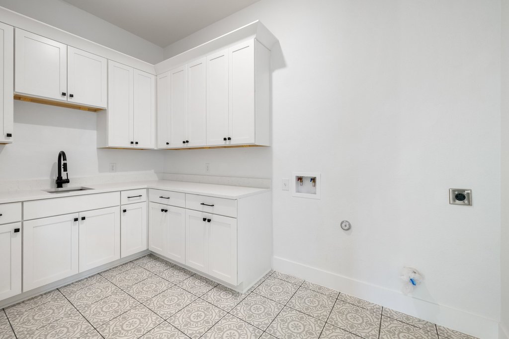47 Peace Pipe Wimberley, TX 78676 - Photo 26 of 28 Laundry area featuring hookup for a gas dryer, cabinet space, washer hookup, and light tile patterned flooring