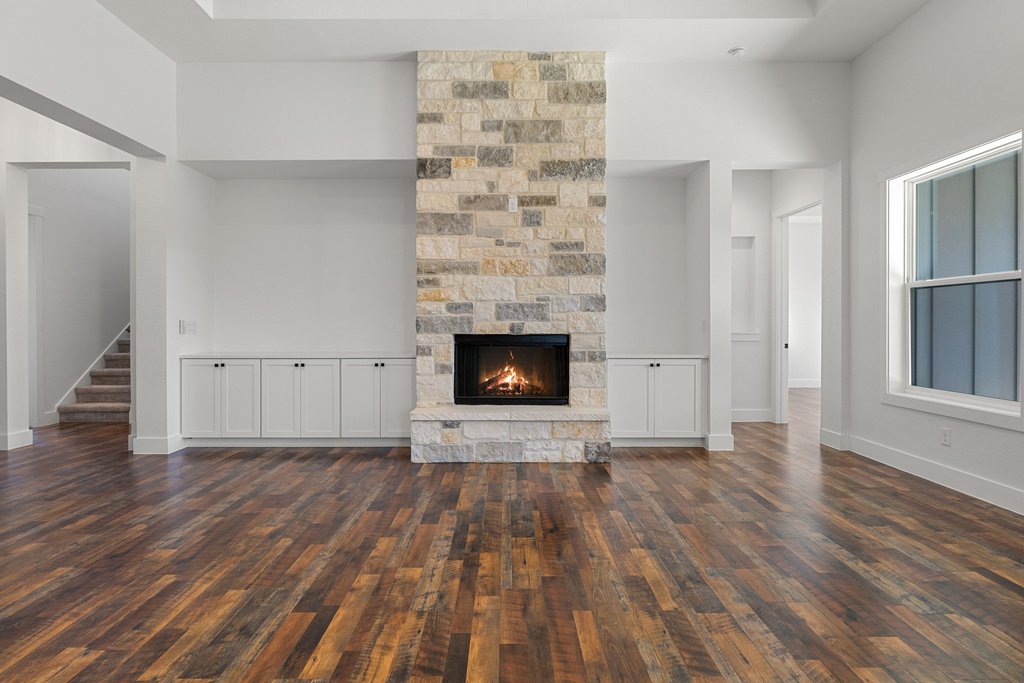 47 Peace Pipe Wimberley, TX 78676 - Photo 7 of 28 Unfurnished living room with a stone fireplace, a high ceiling, and dark wood finished floors