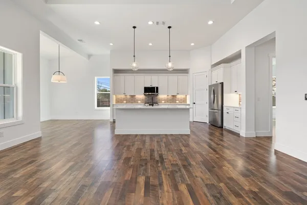 a view of empty room with wooden floor and fireplace
