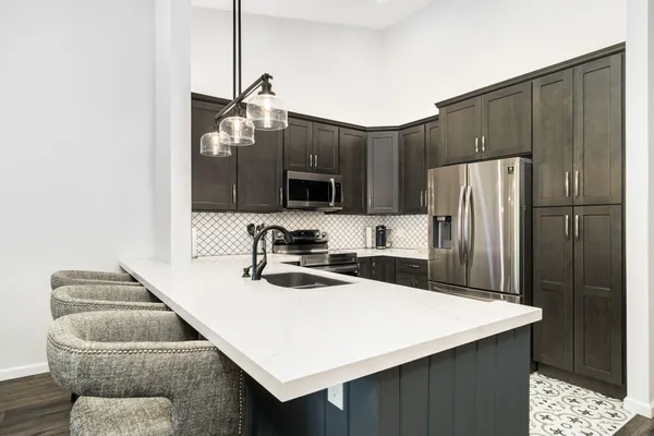 a kitchen with stainless steel appliances a microwave sink refrigerator and cabinets