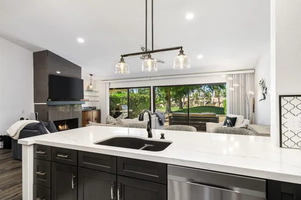 a kitchen with a sink a counter top space and a ceiling fan