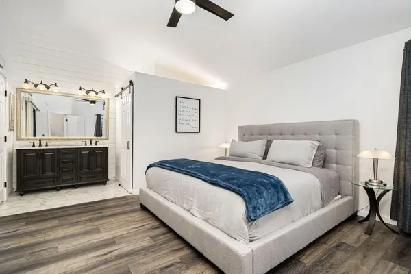 a bedroom with a large bed and a chandelier