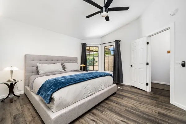 a bedroom with a large bed chandelier and a window