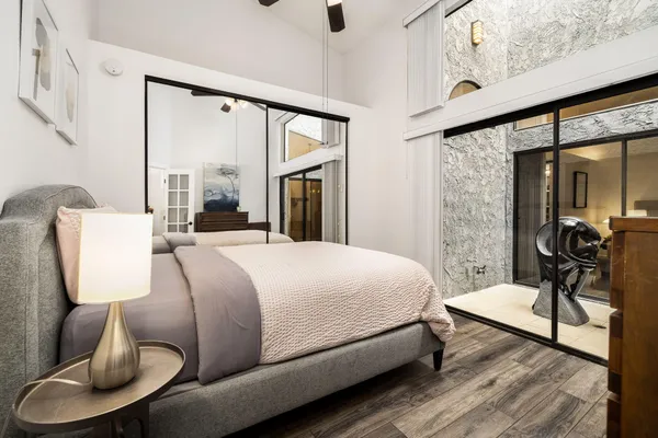 a bedroom with bed and a flat tv screen on dresser
