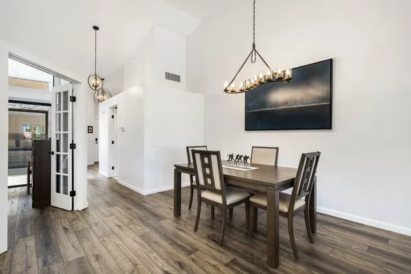 a view of a dining room with furniture wooden floor and a chandelier