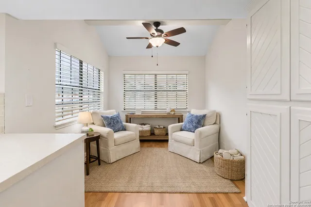 a living room with furniture and a large window with wooden floor