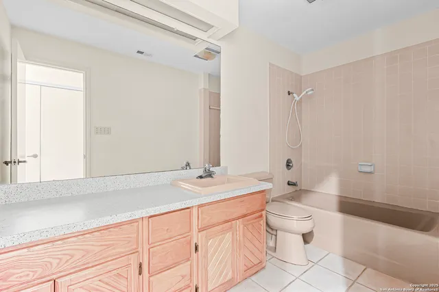 a bathroom with a sink a toilet and a large mirror