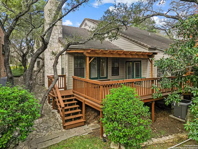 a view of a house with a small yard and wooden fence