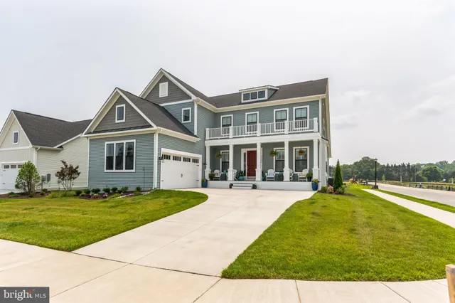 a view of a house with a big yard and large trees