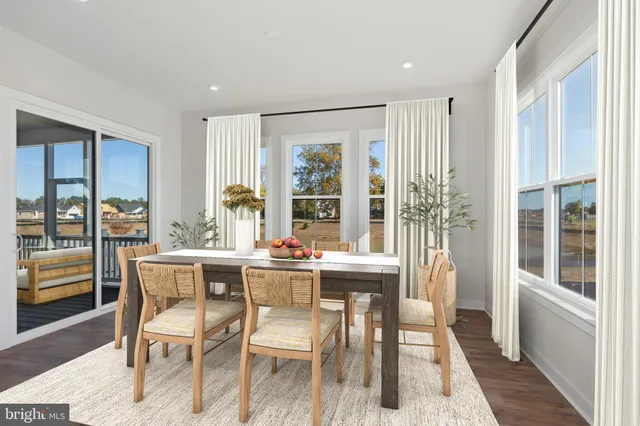 a view of a dining room with furniture large windows and wooden floor