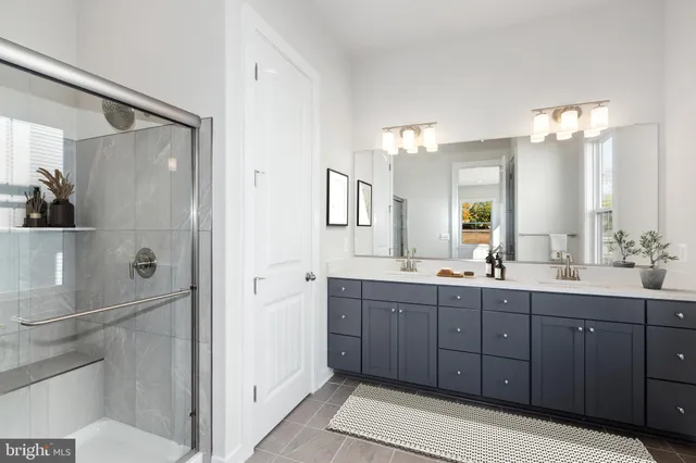 a bathroom with a double vanity sink mirror and shower