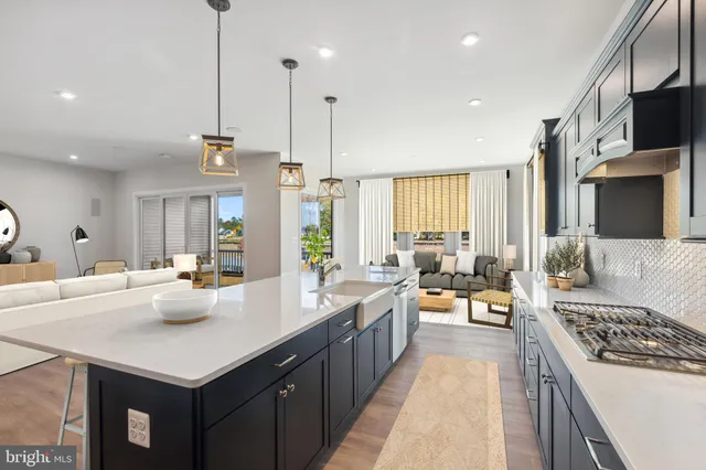 a kitchen with stainless steel appliances a stove a sink a oven a dining table and chairs