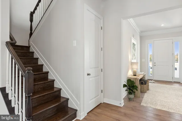 a view of a hallway with wooden floor and stairs