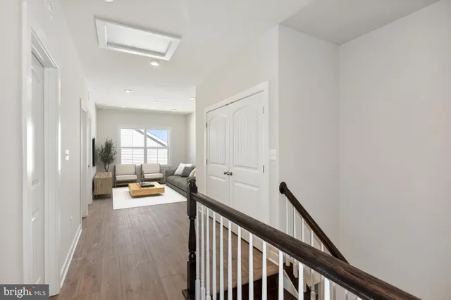 a view of a hallway with wooden floor and furniture