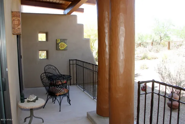 a view of a balcony with chairs and wooden floor
