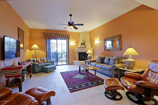 a living room with furniture a fireplace and a chandelier