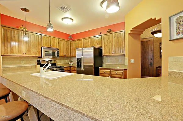 a kitchen with stainless steel appliances a refrigerator sink and microwave