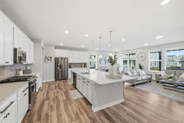 a large white kitchen with a large window and stainless steel appliances