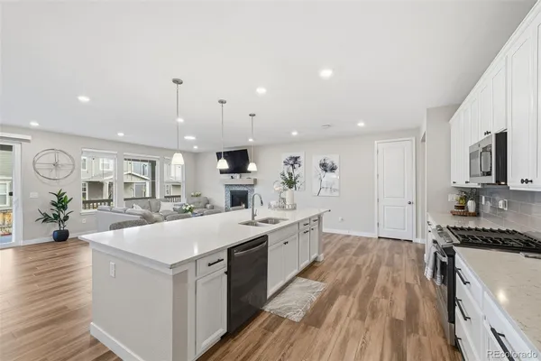 a large kitchen with stainless steel appliances a lot of counter space and wooden floor