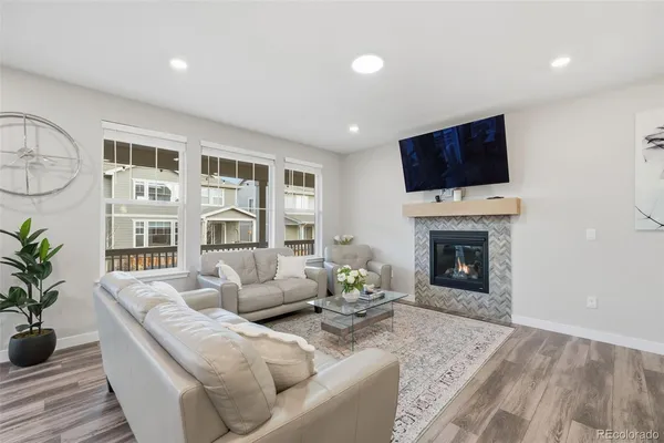 a living room with furniture a flat screen tv and a fireplace