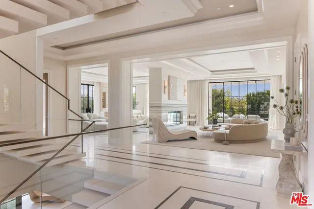a living room with fireplace furniture and floor to ceiling windows