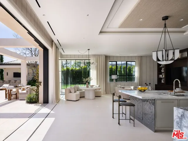 a living room with furniture fireplace and large windows